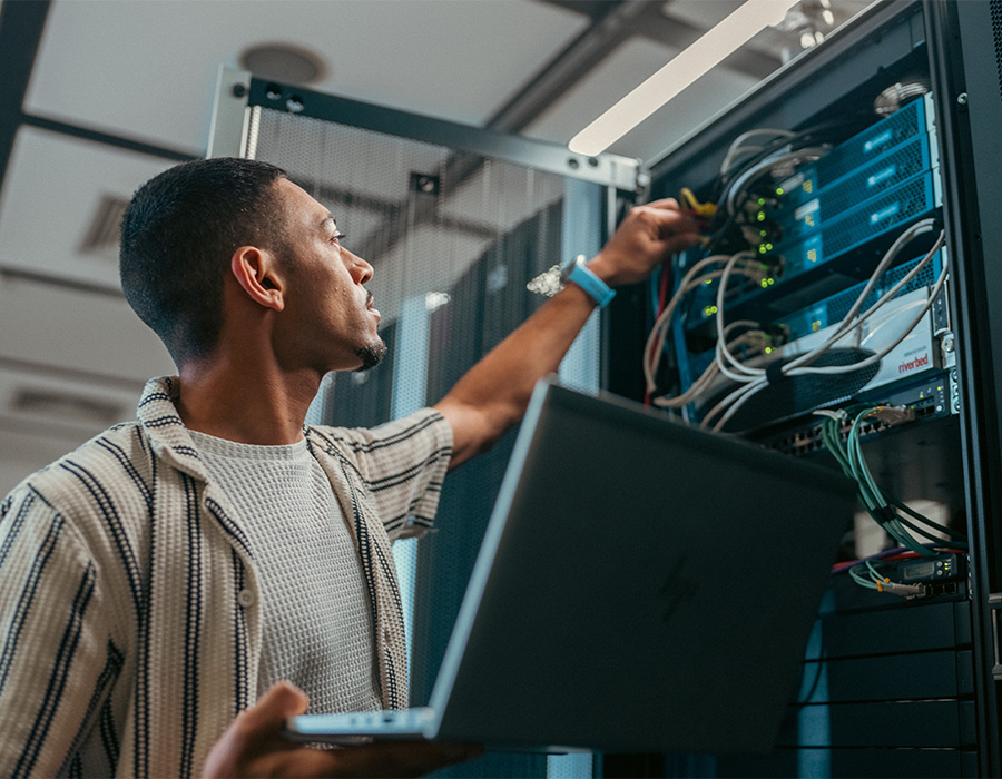 Ein Mitarbeitender im Bereich Informationssysteme arbeitet an der Wartung eines IT-Servers