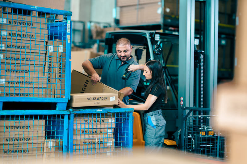 Zwei Praktikanten arbeiten gemeinsam im Lagerbereich der Logistik